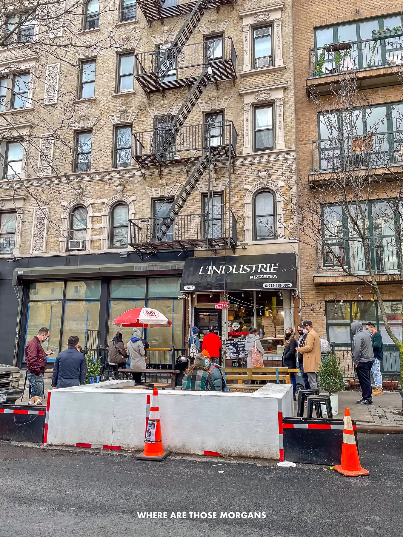 People queuing up outside a pizza place in NYC called L'Industry