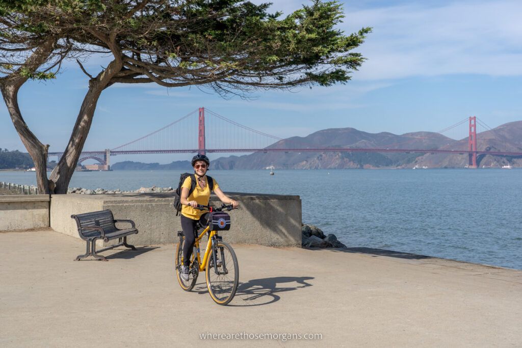 Cycling on a road next to SF Bay with Golden Gate Bridge in background