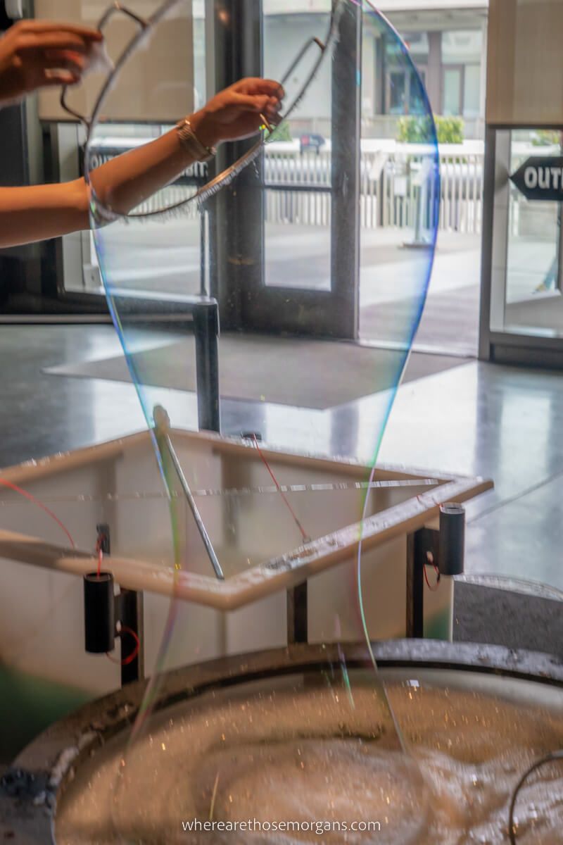 Woman making a large bubble at the Exploratorium