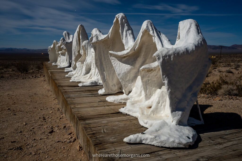 Long line of ghost statues in Rhyolite near Death Valley on a day trip from Las Vegas ghosts illuminated by moonlight