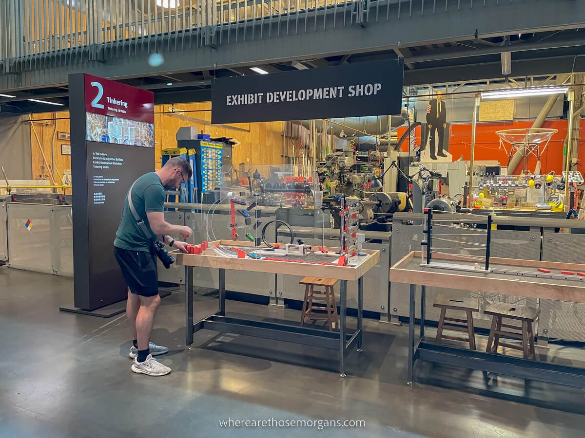 Man playing with exhibit near the exhibit development workshop in the tinkering gallery