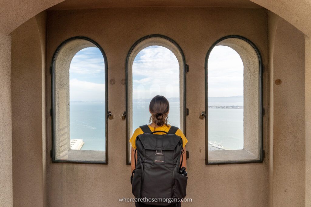 Woman looking out the windows at Coit Tower