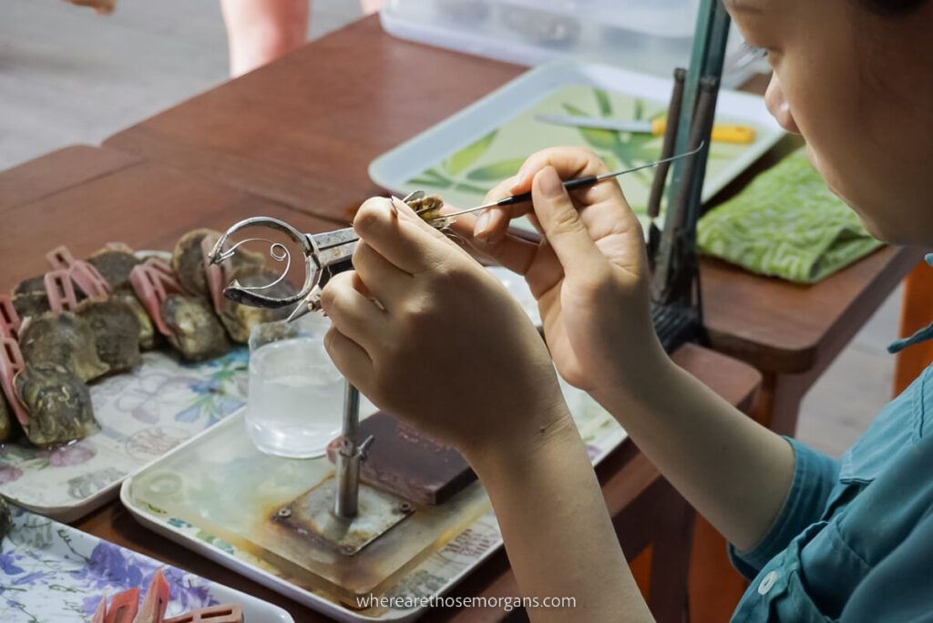 Woman examining a pearl at a pearl farm in Halong Bay
