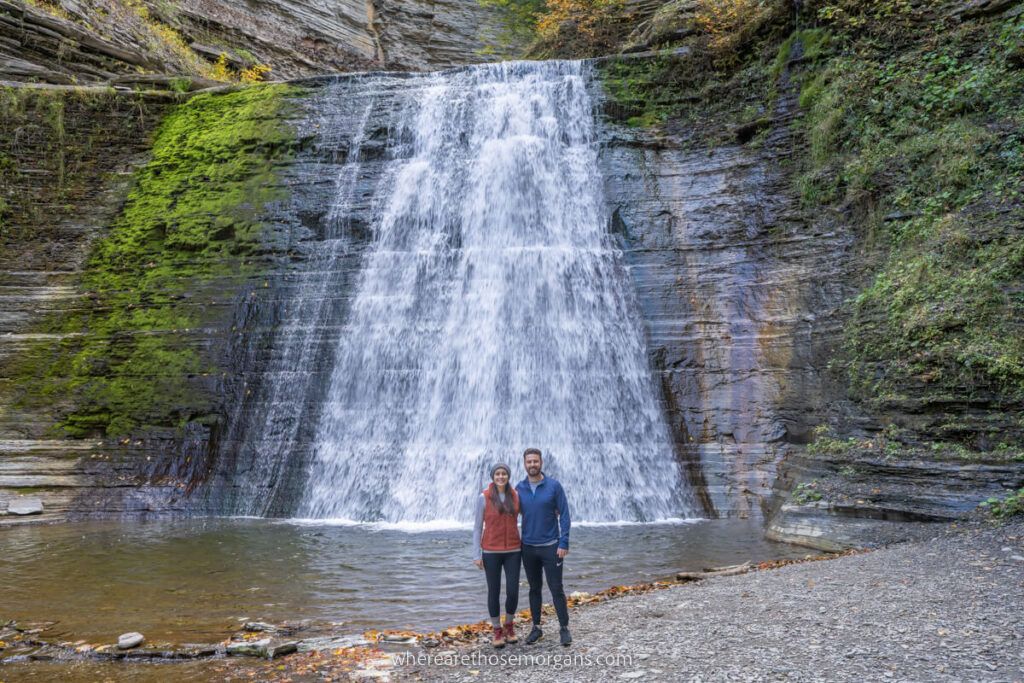 Man and women posing for a photo in front of Lower Falls