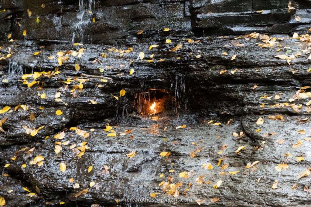 A hidden grotto with a small flame flickering