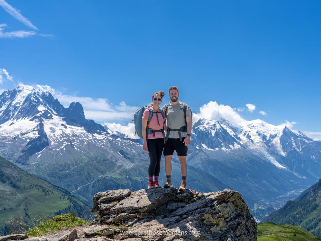 Mark and Kristen Morgan from Where Are Those Morgans travel hiking and photography blog enjoying the amazing Tour du Mont Blanc hike on a hot day with blue sky and snow capped mountains