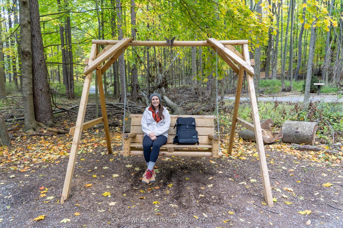 Person sitting on wooden bench at Letchworth State Park along the Autism Nature Trail