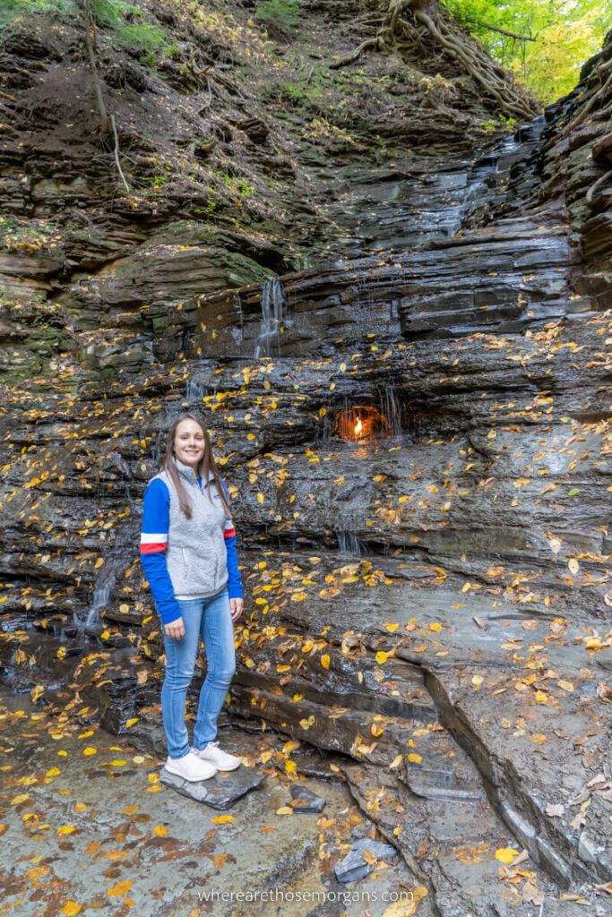 Woman standing by Eternal Flame Waterfall in autumn