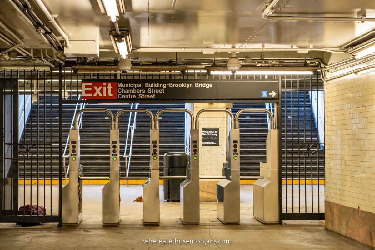 Photo of an empty subway station exit in New York with nobody at the turnstyles or on the steps