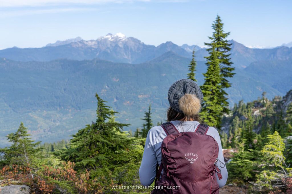Hiker with Osprey backpack enjoying views over distant mountain peaks