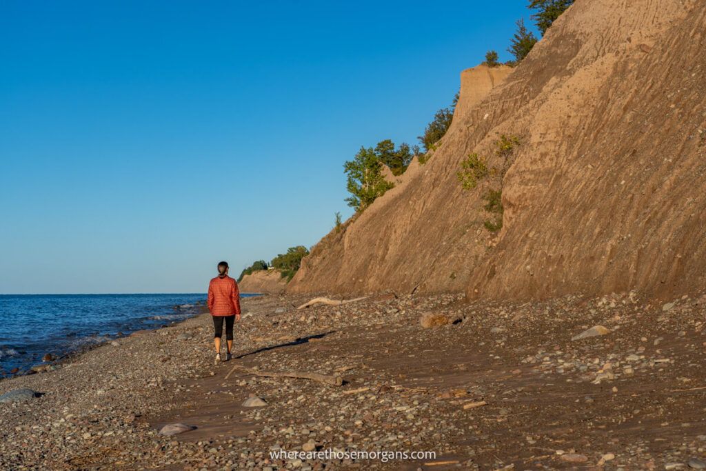 Woman walking the shoreline of Lake Ontario at Chimney Bluffs State Park