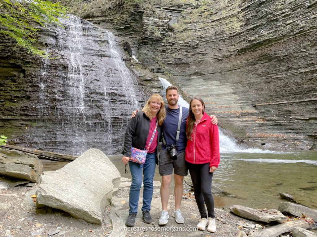 Three people standing in front of the Grimes Glen waterfall