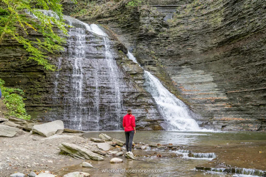 Person standing underneath large waterfall in Grime Glen Park