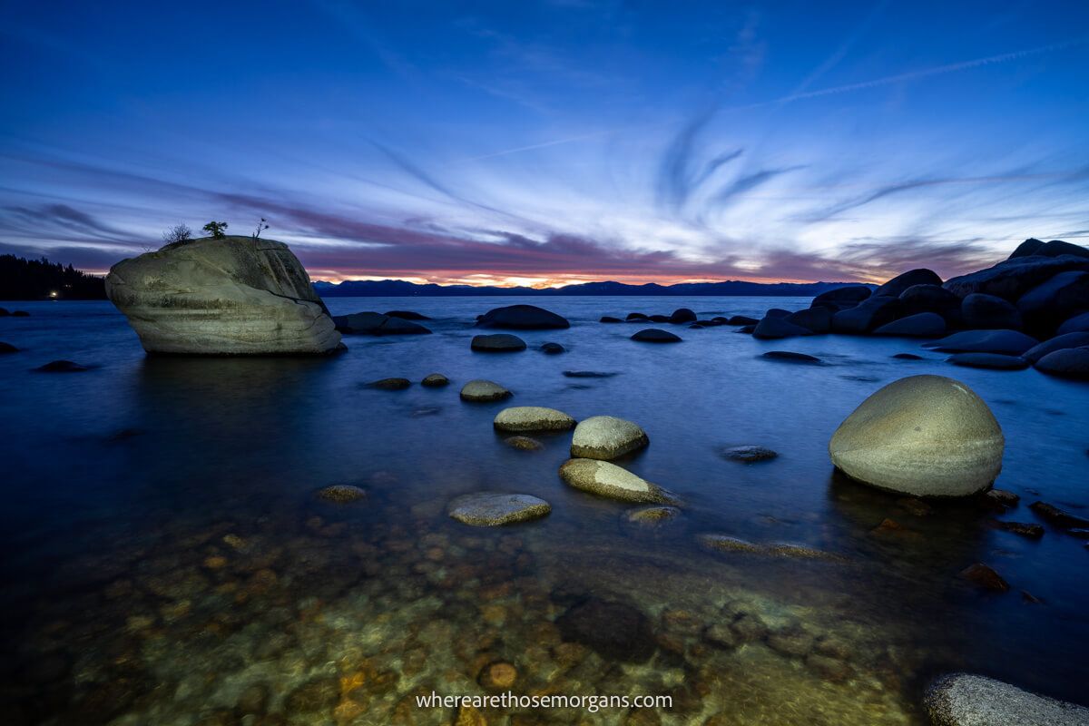 Bonsai Rock in Lake Tahoe at night in twilight with rocks lit up by flashlights