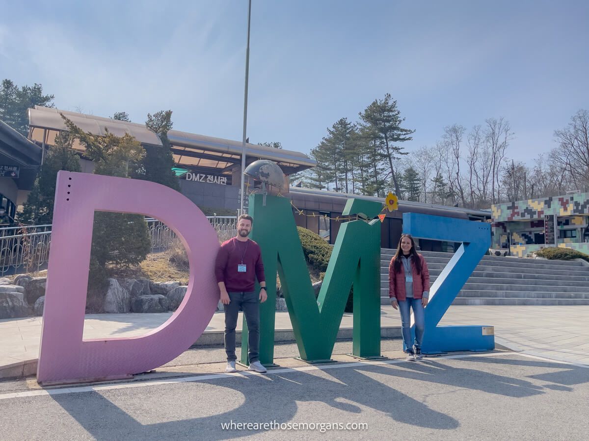 Man and Women posing for a photo with the famous DMZ sign at the 3rd tunnel