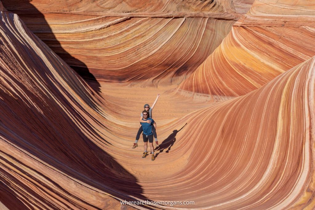 Man and woman posing for a fun photograph while hiking inside the Wave in Arizona