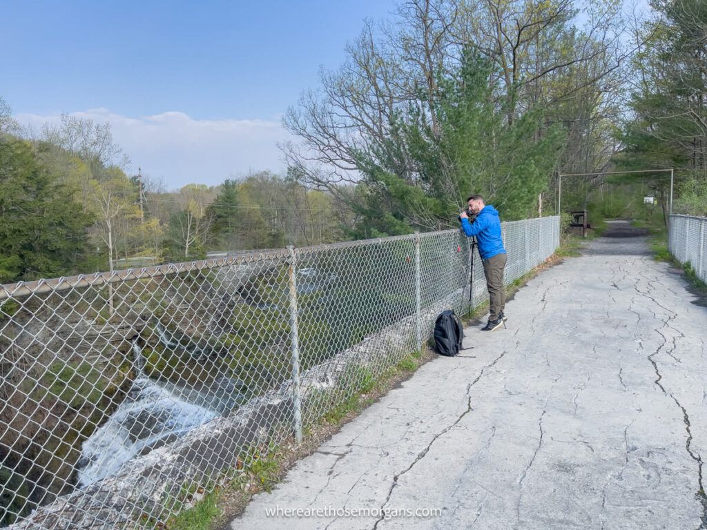 Man taking a photograph of Upper Taughannock Falls near Ithaca, NY