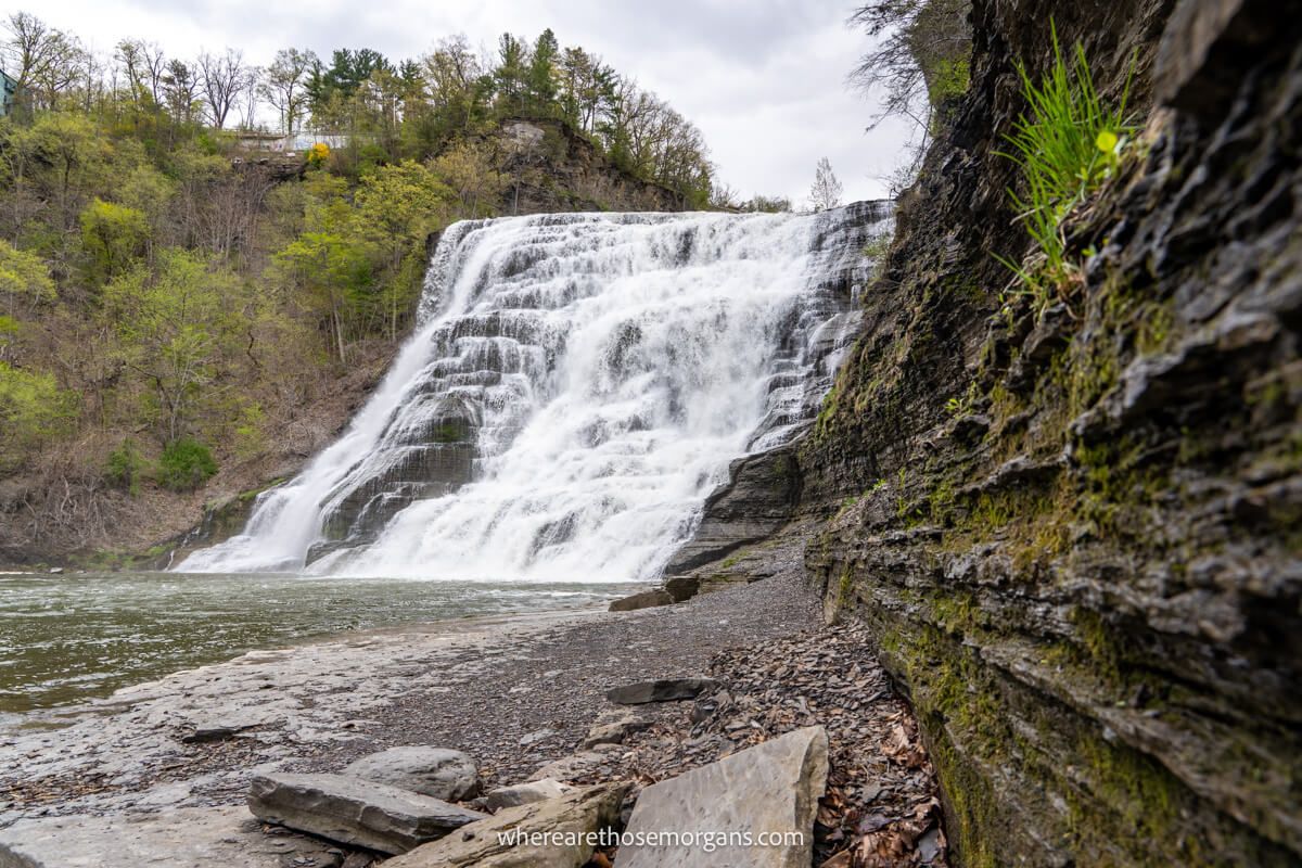 Tall single drop waterfall as seen from the side along a curving cliff wall at Ithaca Falls NY