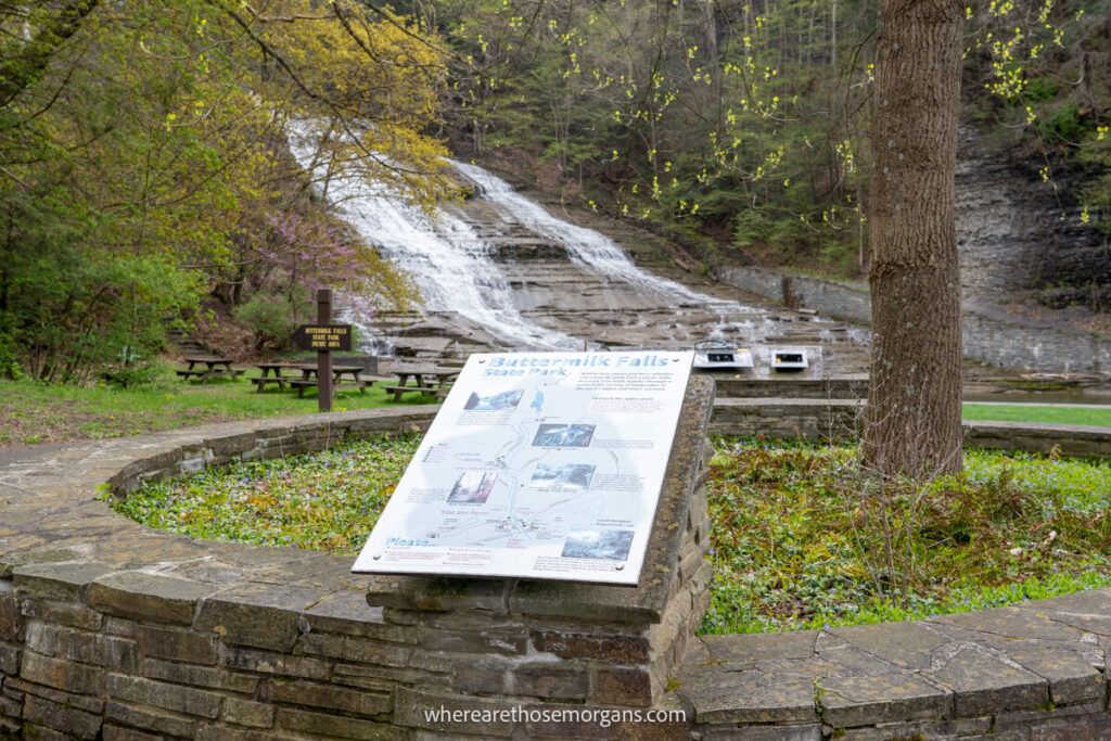 Informational sign located in the beginning of the park in front of a waterfall