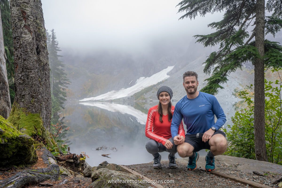 Two hikers kneeling down for a photo while hiking in Washington state