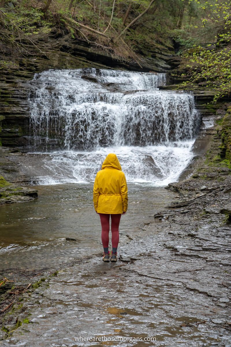 Woman in a yellow rain jacket along the Gorge trail at Buttermilk Falls State Park
