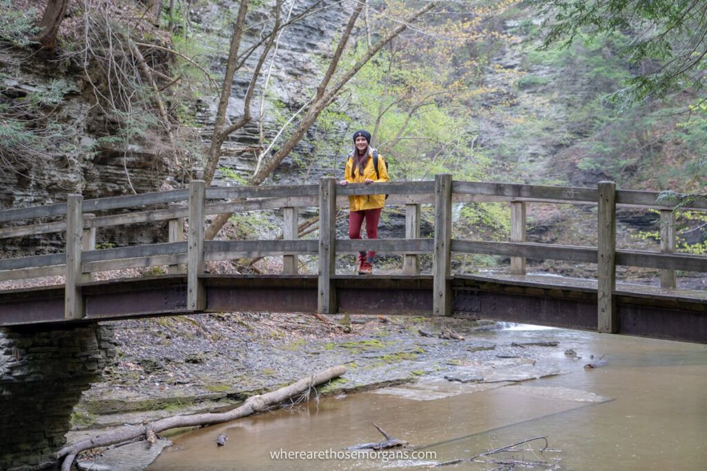 Woman standing on the wooden bridge in Buttermilk Falls