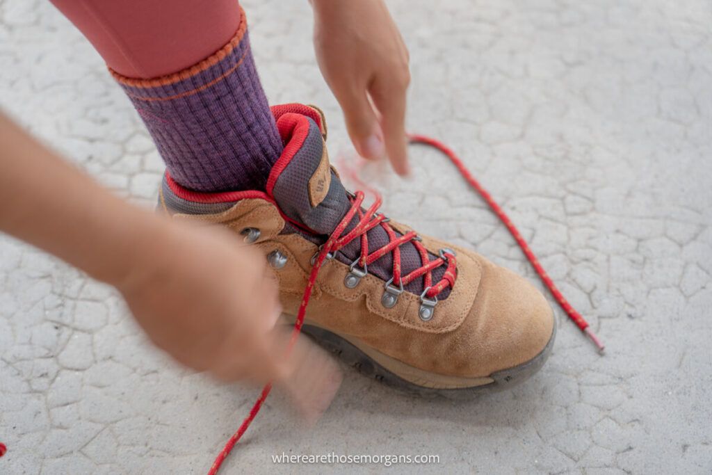 Woman tying her laces for her hiking boots while wear darn tough socks