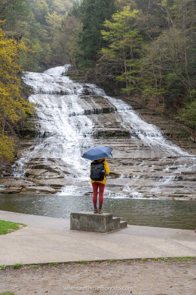 Woman standing in front of fast flowing Buttermilk Falls