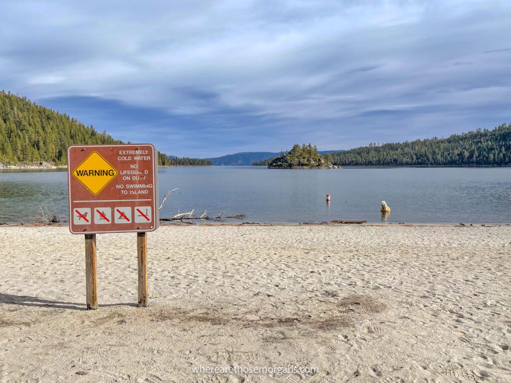 Sign on a beach stating not to swim to the distant island