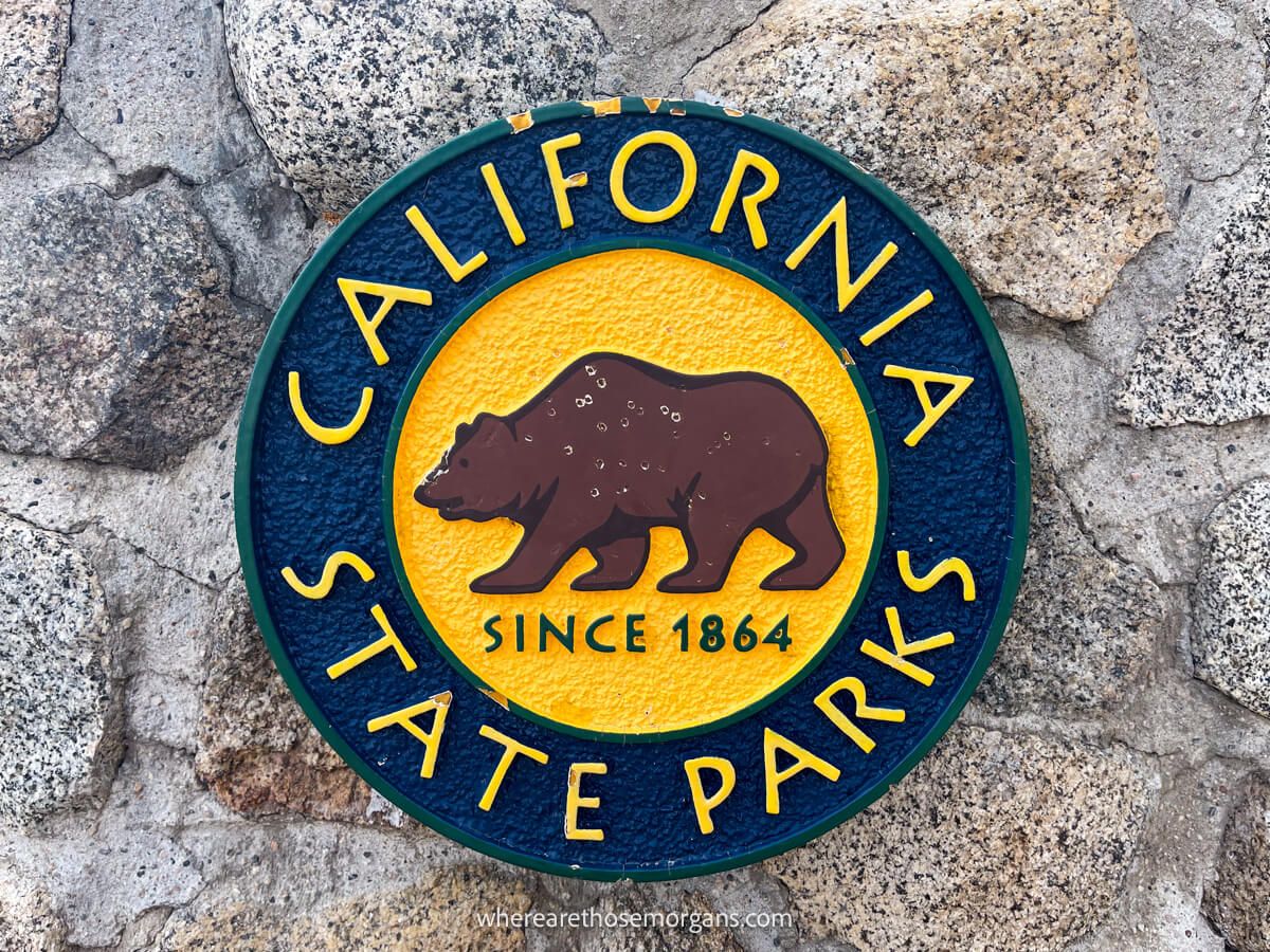 Logo for the California state park agency on a stone wall