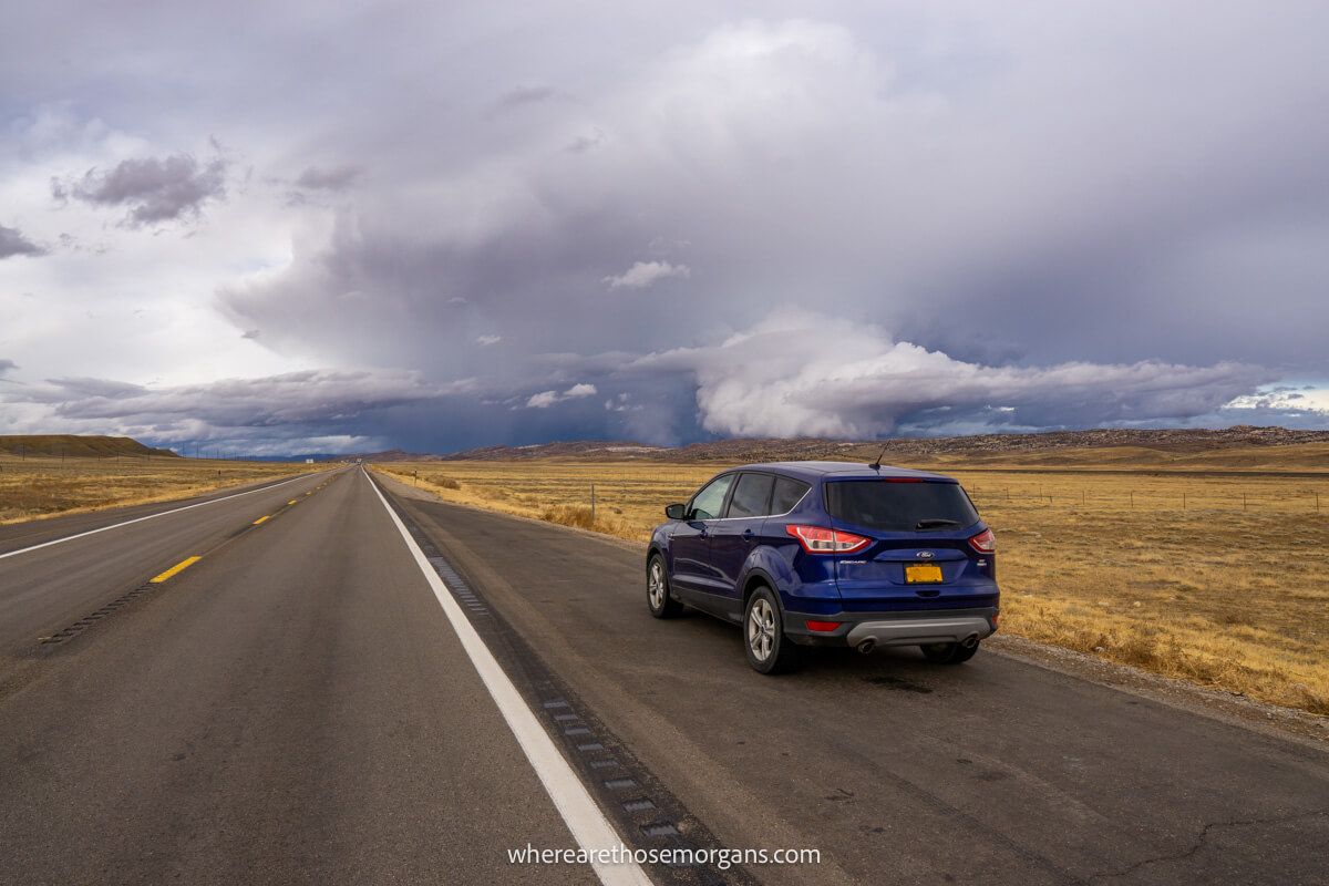 Driving the best Utah road trips along empty roads with thick clouds in the sky