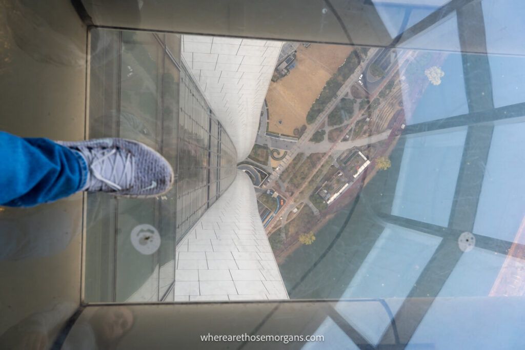 Man standing with his foot over a glass floor