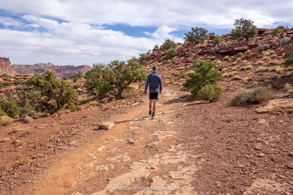 Man hiking to Sunset Point during his Capitol reef national park itinerary