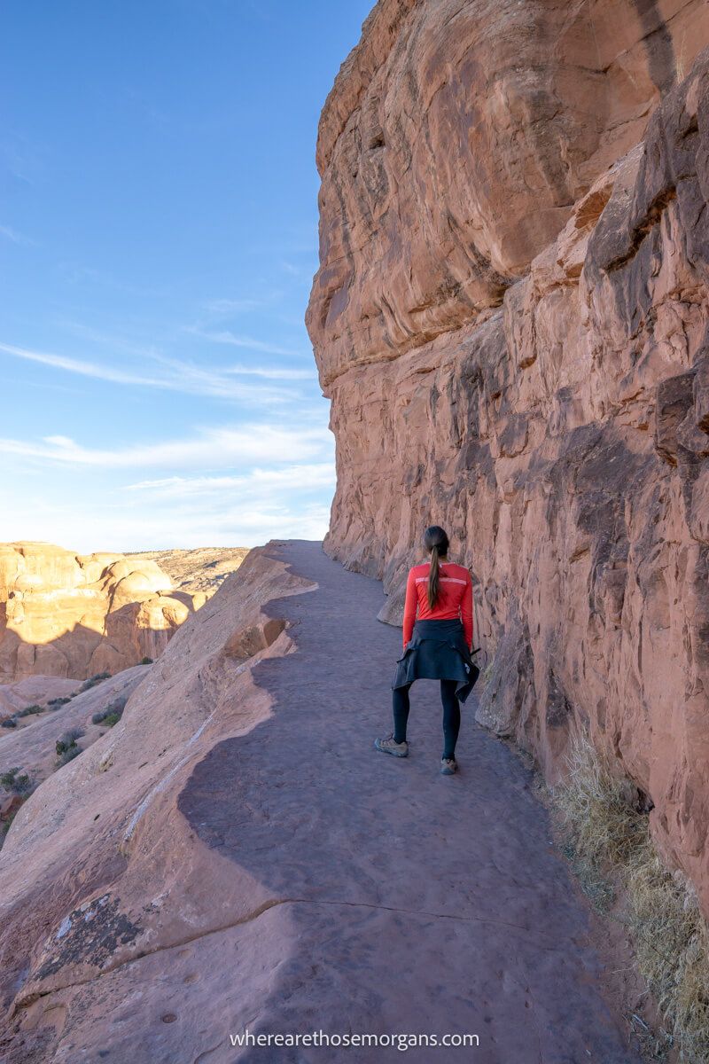 Hiking trail hugging a cliff wall and narrowing with drops to one side