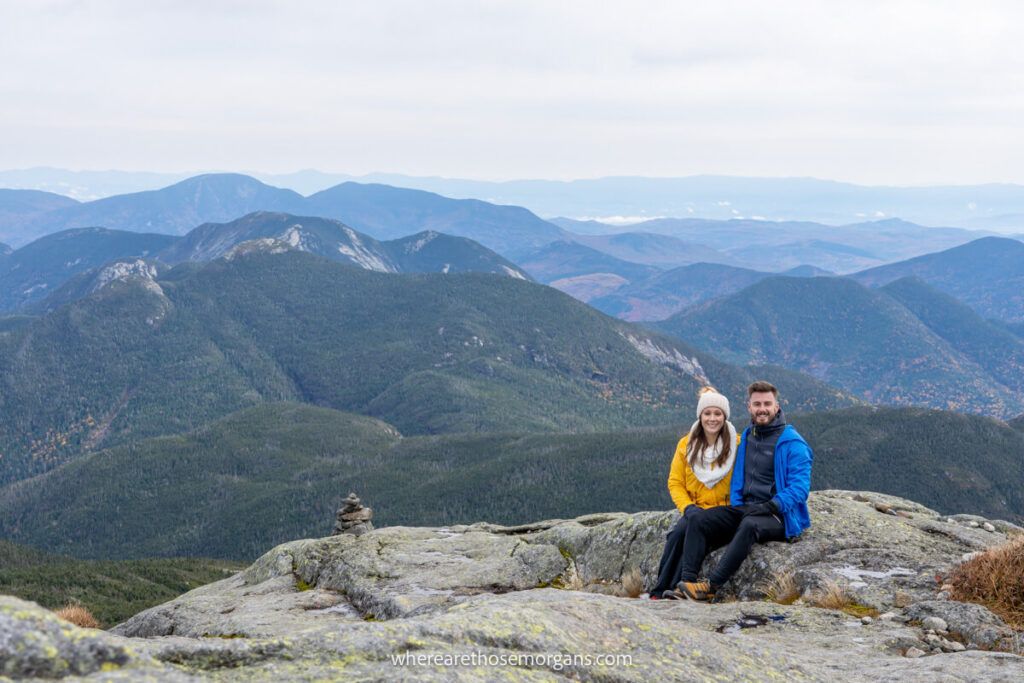 Two hikers sitting at summit of Mount Marcy, the highest peak in New York State