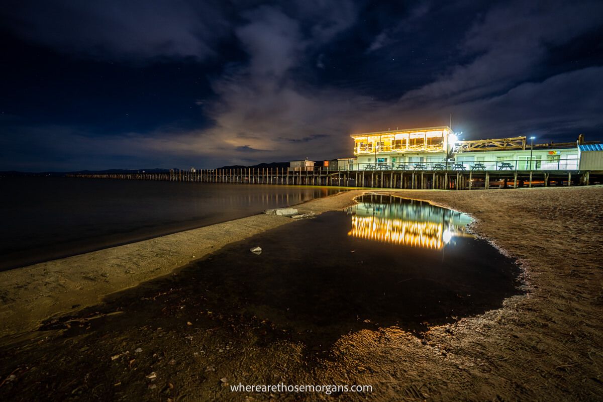 South Lake Tahoe pier and boathouse at night reflecting in shallow water