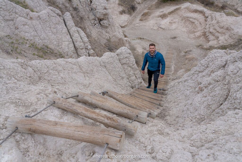 Man on wooden ladder hiking in the Badlands