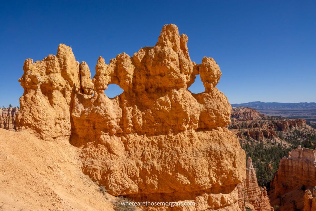 Mask shaped sandstone formation in a national park in Utah with clear deep blue sky