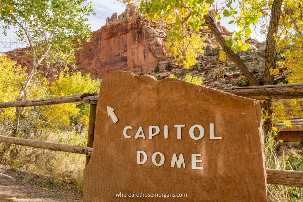 Stone sign pointing to massive rock formation in the desert