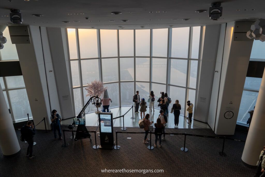 Visitors walking out onto a glass floor of an observation deck