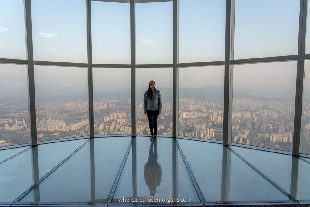 Woman standing on the glass floor of Seoul Sky Observation Deck in Lotte World Tower