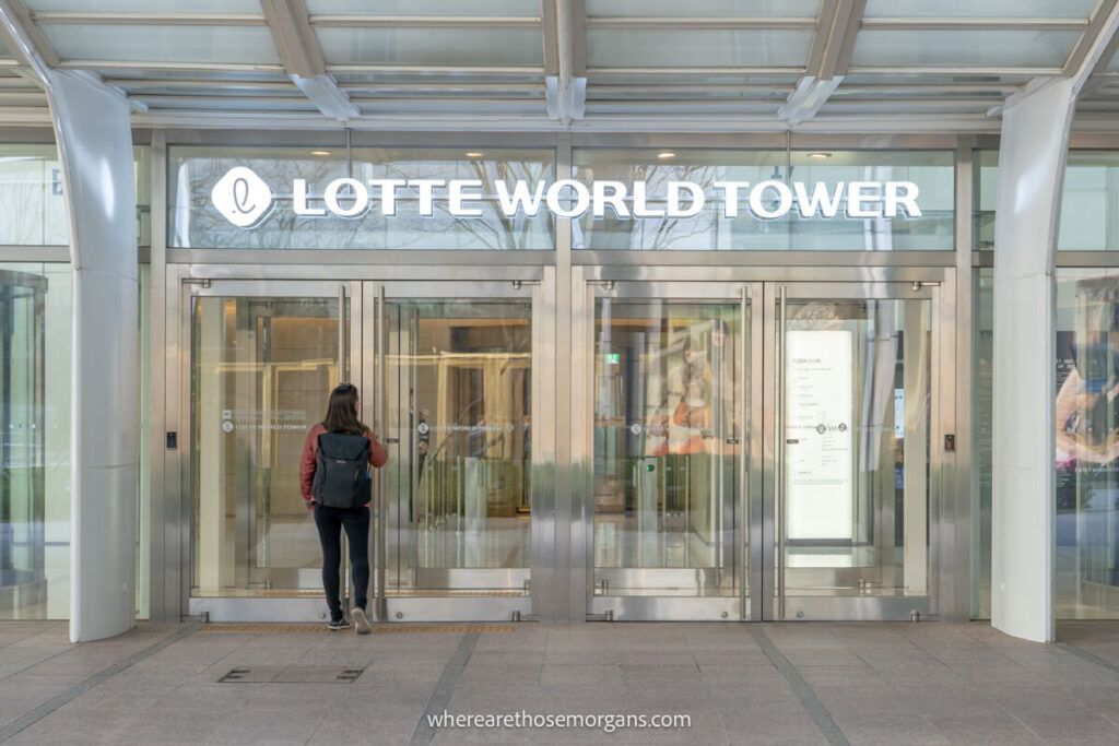 Woman walking into the main entrance of Lotte World Tower in Seoul, South Korea