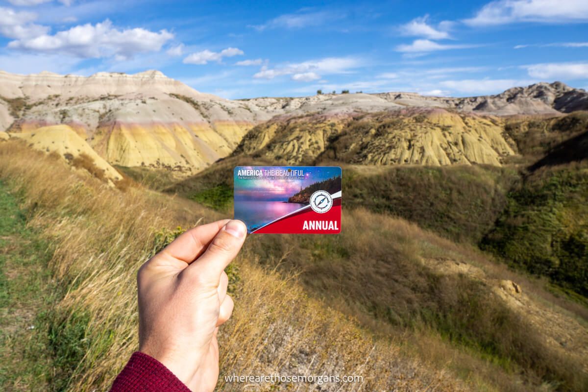 Man holding an America the beautiful pass in from of yellow Mounds overlook