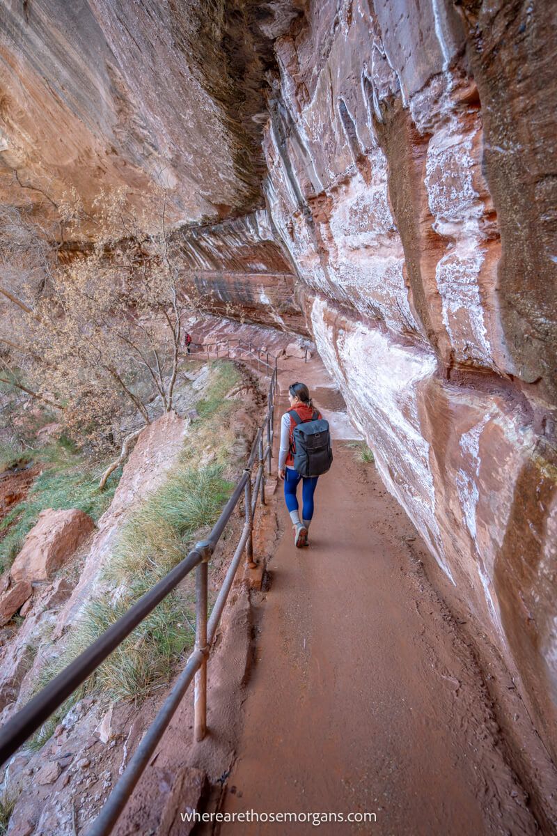Hiker walking underneath an alcove on a narrow path