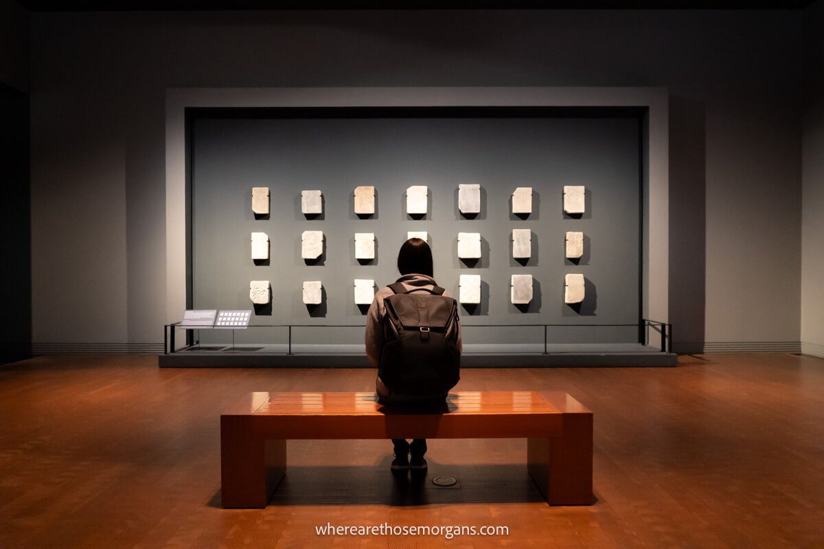 Woman sitting on a bench admiring an exhibit at the National Museum of Korea