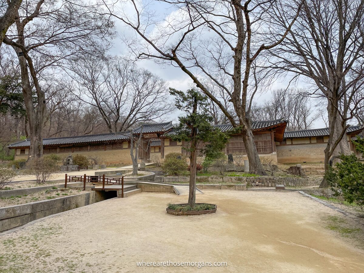View of Seonhyangjae Hall with numerous trees and a small bridge