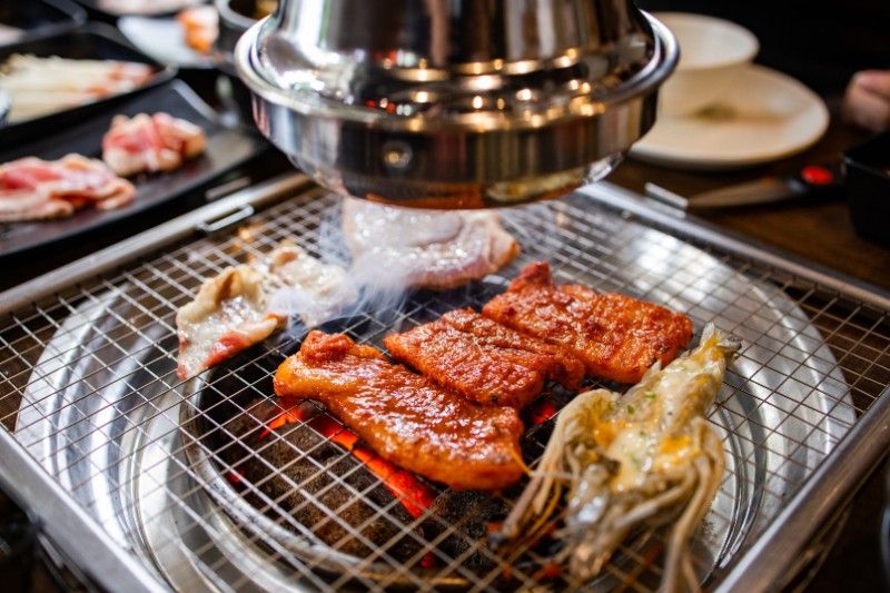 Meat cooking on top of a grill during a Korean BBQ