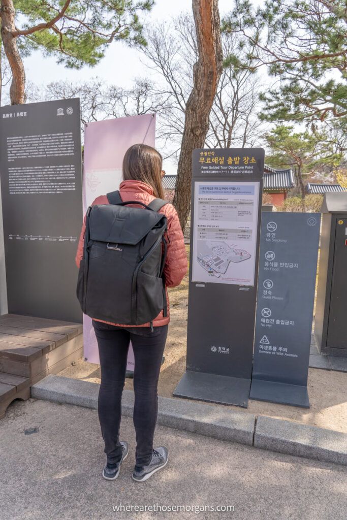Woman reading an informational sign about Changdeokgung Palace
