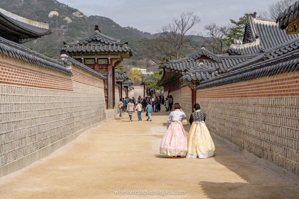 Two visitors inside Gyeongbokgung Palace wearing a hanbok