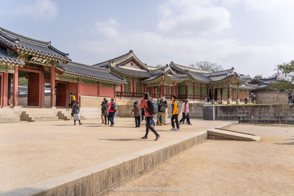 Visitors walking as part of a large group during a guided tour in a Seoul palace
